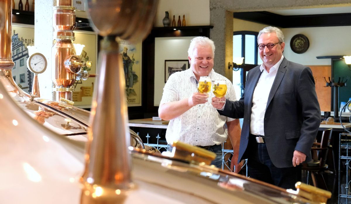 Inhaber Eric Schäffer und Braumeister stoßen an